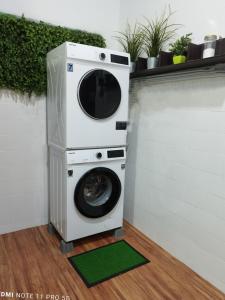 uma máquina de lavar e secar roupa no canto de um quarto em Basrie Villa Pagoh - Mini Cinema , Private Pool , Wi-Fi , NetFlix em Muar
