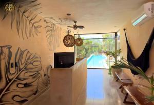 ein Wohnzimmer mit Fernseher und Swimmingpool in der Unterkunft Penthouse Privado en Tulum in Tulum