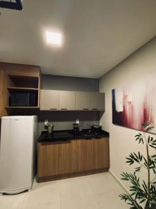 een keuken met een witte koelkast en houten kasten bij Studios London in Resende