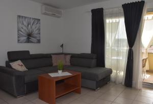 a living room with a couch and a coffee table at Apartmani Andrea in Čižići