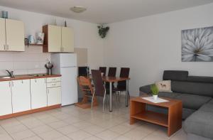 a kitchen and a living room with a couch and a table at Apartmani Andrea in Čižići