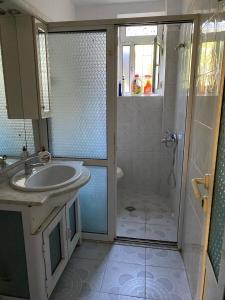 uma casa de banho com um chuveiro, um lavatório e um chuveiro em Castle Berat em Berat