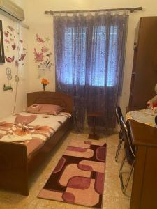 um quarto com uma cama, uma janela e um tapete em Castle Berat em Berat