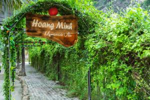 a sign on the side of a field of trees at Hoang Minh Mountainside Villa in Ninh Binh