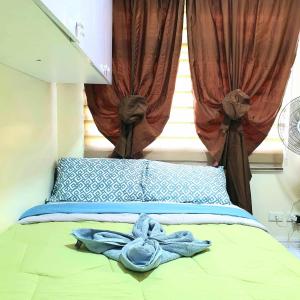 łóżko z niebieskim ręcznikiem i oknem w obiekcie Ma. CRISTINA w mieście Manila