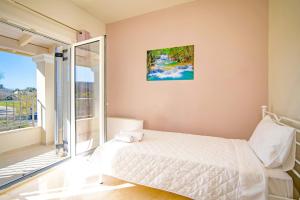 a bedroom with a bed and a balcony at Villa Alegria a Casa II by Villa Plus in Sfakerá +28 photos