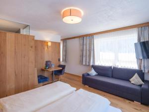 een hotelkamer met een bed en een bank bij Hotel Alpenblick in Bach
