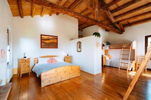 Agriturismo Le Noci في Tarzo: غرفة نوم بسرير وارضية خشبية