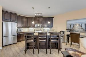 una cocina con una gran isla con taburetes de bar en Your personal oasis! 3 bedroom condo! Top floor!, en West Kelowna