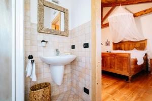 a bathroom with a sink and a bed at Agriturismo Le Noci in Tarzo