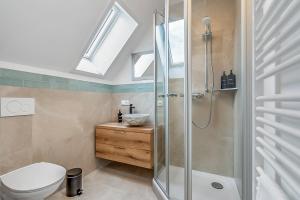 a bathroom with a shower and a toilet and a sink at NAMASTÉ Homes - Ferienwohnung mit Dachterrasse in Bad Windsheim