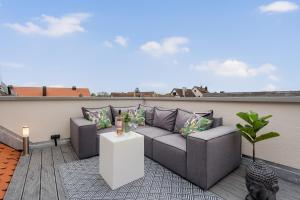 a rooftop patio with a couch on a roof at NAMASTÉ Homes - Ferienwohnungen - Altstadt - 2 Schlafzimmer in Bad Windsheim