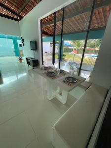 a living room with a white table and a television at Casa de campo aldeia - pe in Camaragibe