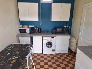 a kitchen with a washing machine and a microwave at Gîte au gré du Canal in Selles-sur-Cher