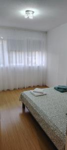 una camera con letto e finestra con tende bianche di Župski TRG ad Aleksandrovac