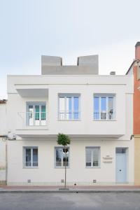 um edifício branco com uma árvore em frente em Luxury Houses La Mar de Bonita em Guardamar del Segura
