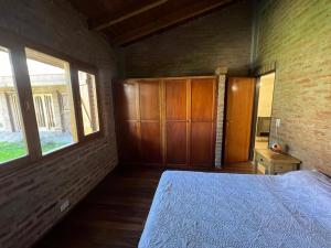 a bedroom with a bed and a brick wall at Habitación en chalet, Cipolletti in Cipolletti