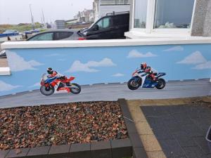 two people are riding motorcycles on a street at NUMBER 5 Portrush Road, Portstewart in Portstewart