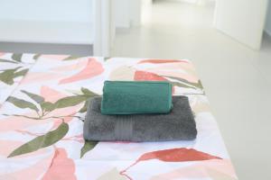 a green wallet sitting on top of a bed at Ida Apartments in Sarandë