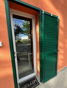 una puerta verde con una ventana en el lateral de un edificio en La casa di Giada, en Imola