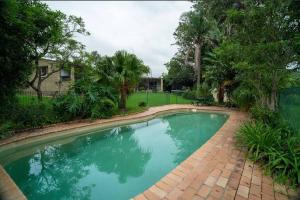 una piscina con una pasarela de ladrillo alrededor en Yasar farm stay Marshall view, 