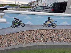 Dos personas están conduciendo motocicletas en una carretera en NUMBER 5 Portrush Road, Portstewart, en Portstewart