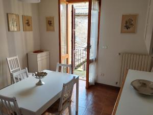 a dining room with a white table and chairs at Casa Vacanze Corso Amendola in Bevagna