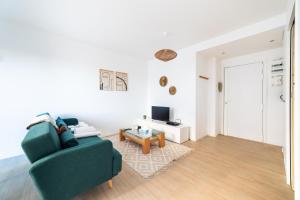 uma sala de estar com um sofá verde e uma mesa em Appartement rénové Proche Paris - 5 min transport em Montrouge