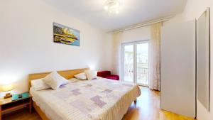 una camera con un letto e una grande finestra di Apartments by the beach a Duće
