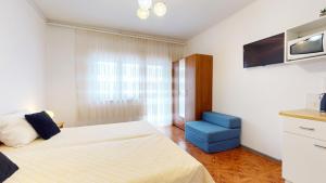 una camera con letto e sedia blu di Apartments by the beach a Duće