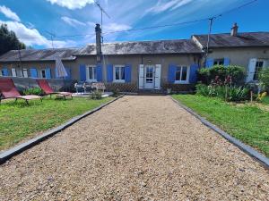 uma casa com duas cadeiras vermelhas em frente em Gîte au gré du Canal em Selles-sur-Cher