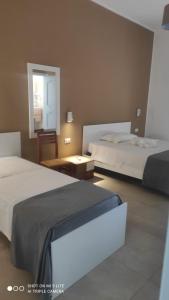 a hotel room with two beds and a window at B&B Li Manca in Surbo