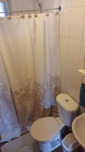 a bathroom with a toilet and a shower curtain at Cabaña el ricky in Cabrero