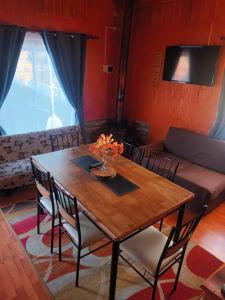 a dining room table with chairs and a couch at Cabaña el ricky in Cabrero