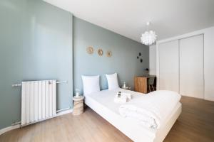 um quarto com uma cama branca e um radiador em Appartement rénové Proche Paris - 5 min transport em Montrouge