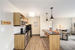 eine offene Küche und ein Wohnzimmer in einem Apartment in der Unterkunft Candlewood Suites - Ocala I-75, an IHG Hotel in Ocala