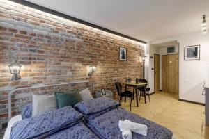 Un dormitorio con una pared de ladrillo y una cama en Weronika's Urban Hideaway, en Wroclaw
