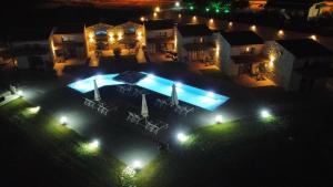 an aerial view of a house with a swimming pool at night at Petrina Bolosis 