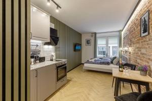 cocina y sala de estar con cama de fondo en Weronika's Urban Hideaway, en Wroclaw