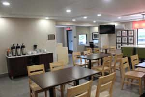 un restaurante con mesas y sillas y TV en Country Inn & Suites by Radisson, Dunbar, WV en Dunbar