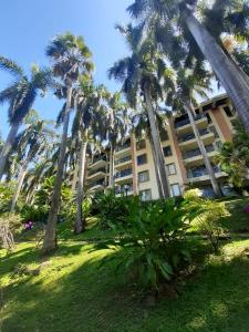 een gebouw met palmbomen ervoor bij Apartamento Condominio Girardot Resort Apto 6-402 Vista a las montañas ,WI-FI- RNT # 96655 in Girardot