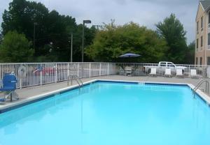 a large swimming pool with chairs and an umbrella at Fairfield Inn & Suites Christiansburg in Christiansburg