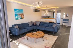 ein Wohnzimmer mit 2 blauen Sofas und einem Tisch in der Unterkunft Çeşme lüks huzurlu yeni villa in Cesme