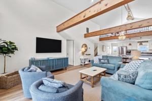 sala de estar con muebles azules y TV de pantalla plana en 5802 - Free Bird by Resort Realty en Nags Head