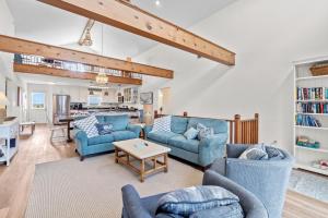 una sala de estar con 2 sofás azules y una mesa. en 5802 - Free Bird by Resort Realty en Nags Head