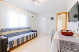 a bedroom with a bed and a table and a television at The Blue House in Leptokarya