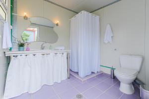 a bathroom with a white shower curtain and a toilet at The Blue House in Leptokarya +21 photos