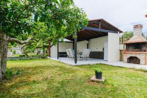 a backyard with a table and chairs and a fireplace at The Blue House in Leptokarya
