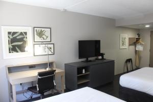 Habitación de hotel con escritorio, cama y TV. en Country Inn & Suites by Radisson, Dunbar, WV en Dunbar