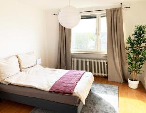 um quarto com uma cama e uma grande janela em Komfortabel & Helles Apartment Nah am Flughafen, Frankfurt City, Wiesbaden und Rüsselsheim em Mörfelden-Walldorf